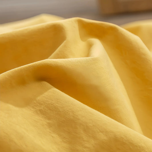 Soft yellow cotton doona cover with gentle folds and premium texture