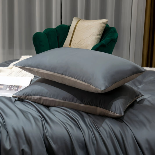 Luxury grey satin pillowcases and bedding set with elegant green velvet chair backdrop