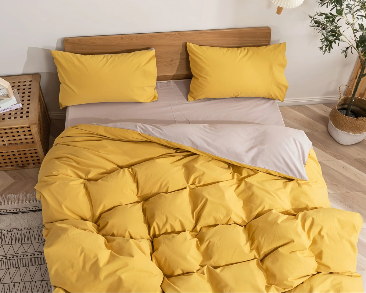 Yellow cotton doona cover set with matching pillowcases on a wooden bed frame